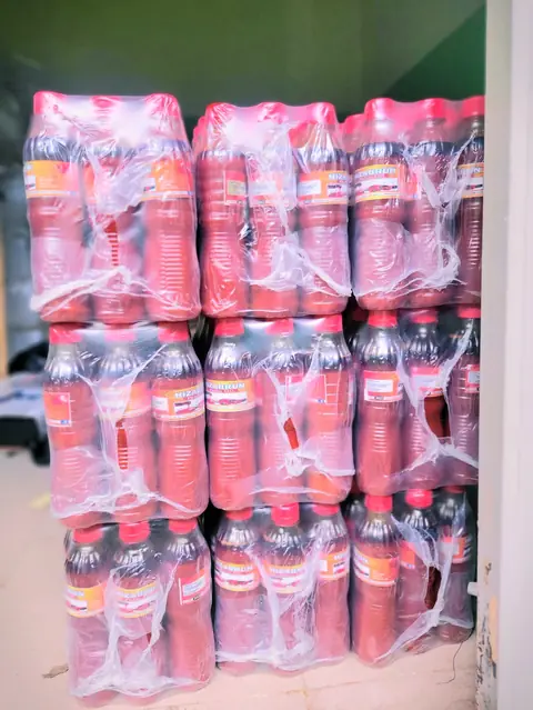 Wrapped packs of Hizabrun Palm Oil bottles stacked in the store